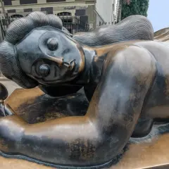 Bronzen beeld van een liggende vrouw met spiegel, een iconisch werk van een bekende beeldhouwer.
