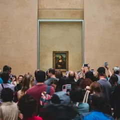 Een menigte bewondert de Mona Lisa, wat is er zo bijzonder aan dit schilderij dat zoveel mensen trekt?