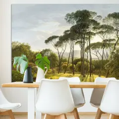 Een schilderij van Hendrik Voogd toont een zonnig landschap met hoge pijnbomen en weelderig groen.