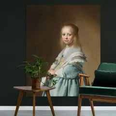 Portret van een meisje in blauwe jurk, geschilderd door Johannes Verspronck. Een groene fauteuil en plantje staan ernaast.