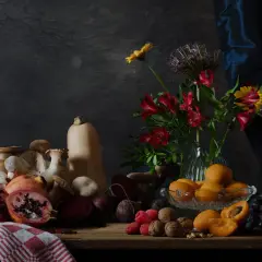 Een rijke **still life** met fruit, groenten, paddenstoelen en bloemen op een houten tafel.