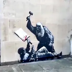 Kunstwerken van Banksy: een rechter slaat met een hamer op een boek, terwijl een figuur onderaan ligt.