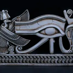 Een gedetailleerd beeld van het Oog van Horus, een symbool uit de Egyptische mythologie, met een vogelkop en slangen. Dit is een prachtig voorbeeld van oude bijbelse kunst.