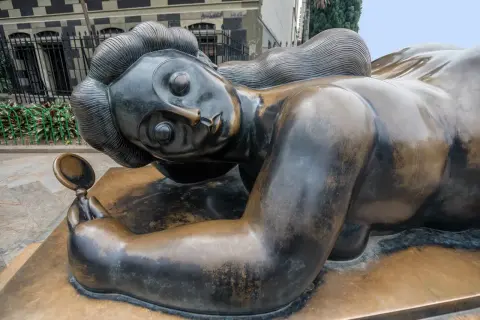 Bronzen beeld van een liggende vrouw met spiegel, een iconisch werk van een bekende beeldhouwer.