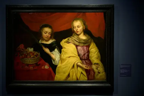Twee meisjes, een met een mand fruit, de ander met een lam. Een stille hint naar de godin van de oorlog, Athena, die wijsheid en oorlog combineert.