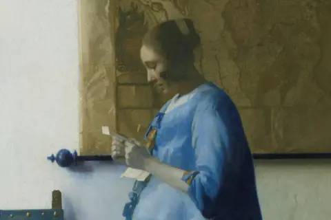 Een brieflezende vrouw in het blauw, verdiept in haar post. De kaart achter haar suggereert een wereld van avontuur.