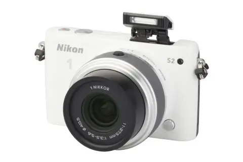 Witte Nikon 1 S2 camera met pop-up flitser en lens.