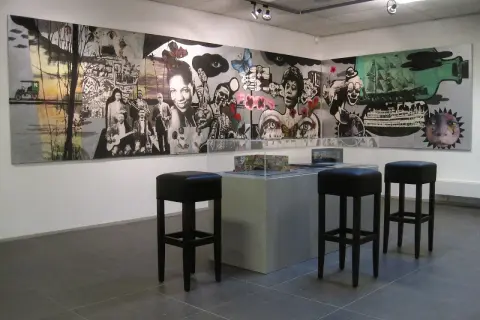 Een muurschildering met jazzmuzikanten en surrealistische elementen, mogelijk van Hans Truijen, in een galerie met barkrukken.