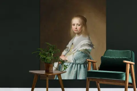 Portret van een meisje in blauwe jurk, geschilderd door Johannes Verspronck. Een groene fauteuil en plantje staan ernaast.