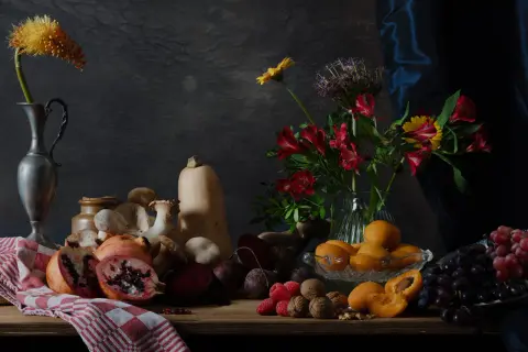 Een rijke **still life** met fruit, groenten, paddenstoelen en bloemen op een houten tafel.
