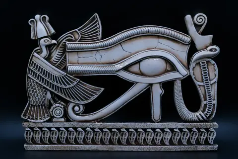 Een gedetailleerd beeld van het Oog van Horus, een symbool uit de Egyptische mythologie, met een vogelkop en slangen. Dit is een prachtig voorbeeld van oude bijbelse kunst.