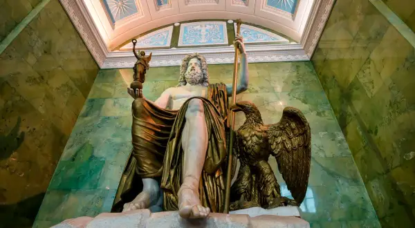 Zittende Zeus, de Romeinse naam is Jupiter, met adelaar en Nikè. Groene marmeren muren en een versierd plafond.