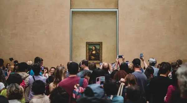 Een menigte bewondert de Mona Lisa, wat is er zo bijzonder aan dit schilderij dat zoveel mensen trekt?