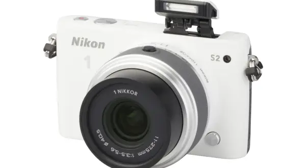 Witte Nikon 1 S2 camera met pop-up flitser en lens.