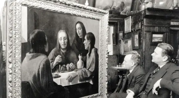 Twee mannen bewonderen een schilderij, mogelijk een van de kunstwerken van Johannes Vermeer, in een kamer vol met andere schilderijen.