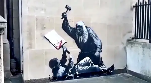 Kunstwerken van Banksy: een rechter slaat met een hamer op een boek, terwijl een figuur onderaan ligt.