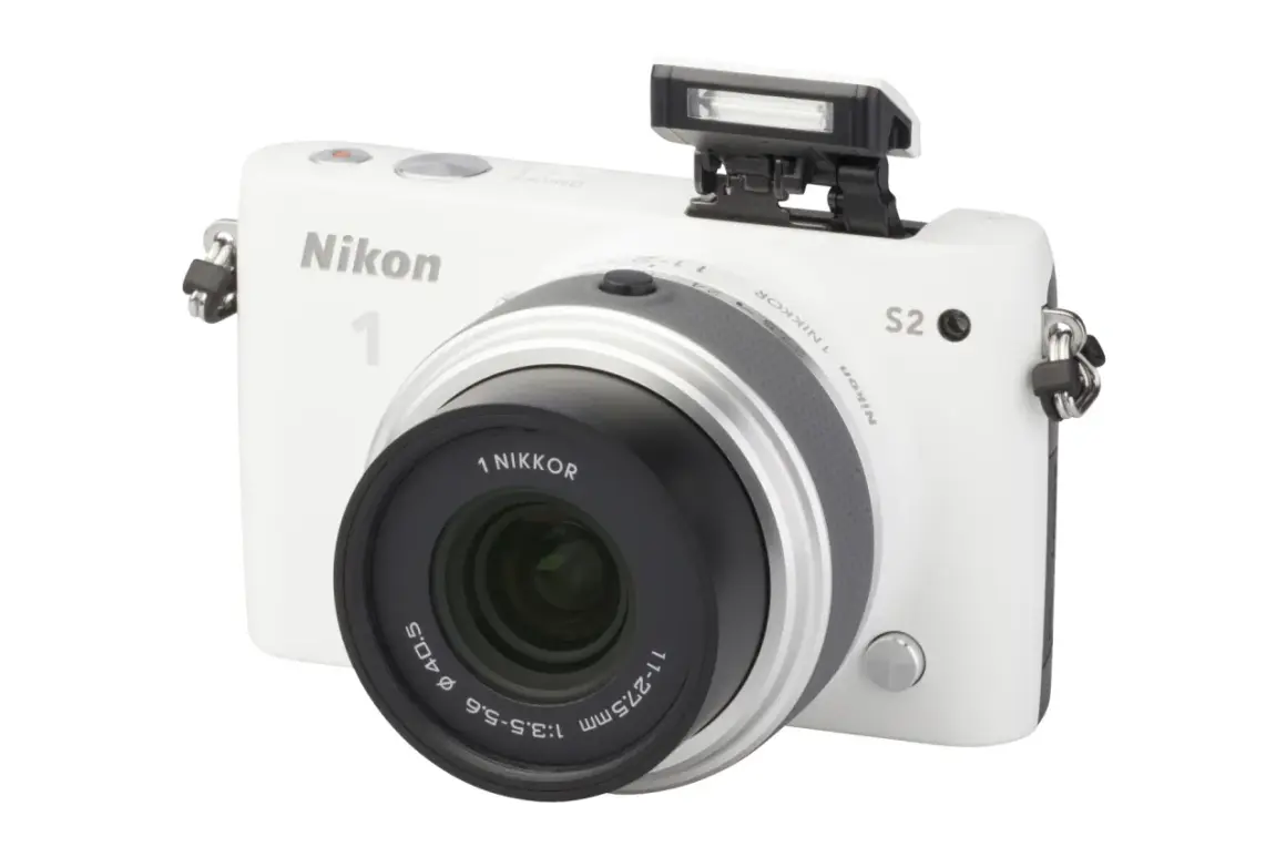 Witte Nikon 1 S2 camera met pop-up flitser en lens.