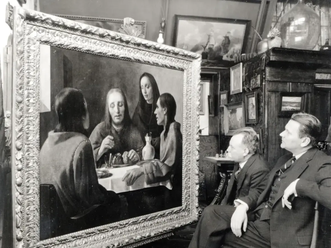 Twee mannen bewonderen een schilderij, mogelijk een van de kunstwerken van Johannes Vermeer, in een kamer vol met andere schilderijen.