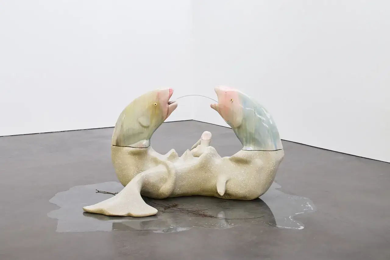 Baukje Dijkstra's sculptuur: twee vissen met open bekken, verbonden door een draad, rusten op een organisch lichaam.