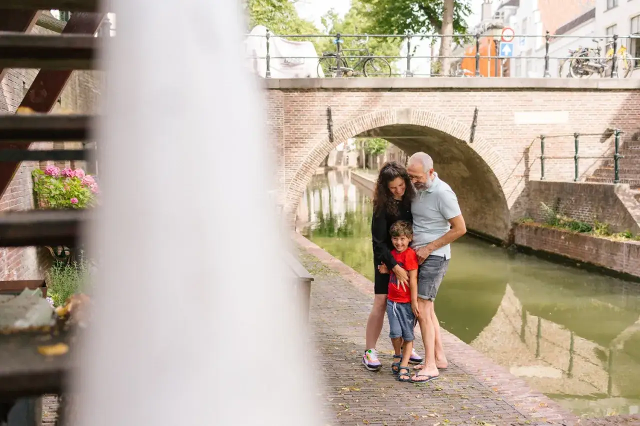 Familie geniet van een zonnige dag bij een gracht in Utrecht. Een perfecte plek voor familiefoto's!