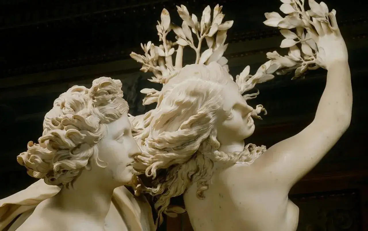 Marmersculptuur van twee figuren, een man en een vrouw, met gedetailleerd haar en bladeren. Een meesterwerk van een bekende beeldhouwer.