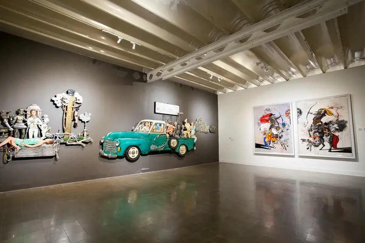 Een surrealistische installatie met een turquoise truck vol figuren, naast een liggend skelet en schilderijen van ruiters. Geerke Catshoek's werk prikkelt de fantasie.