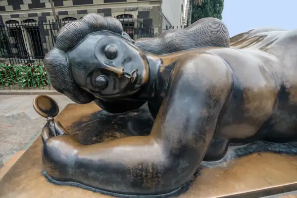 Bronzen beeld van een liggende vrouw met spiegel, een iconisch werk van een bekende beeldhouwer.