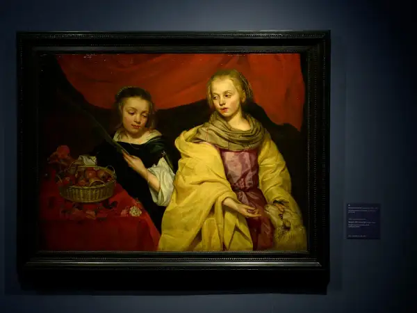Twee meisjes, een met een mand fruit, de ander met een lam. Een stille hint naar de godin van de oorlog, Athena, die wijsheid en oorlog combineert.