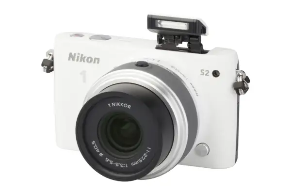Witte Nikon 1 S2 camera met pop-up flitser en lens.