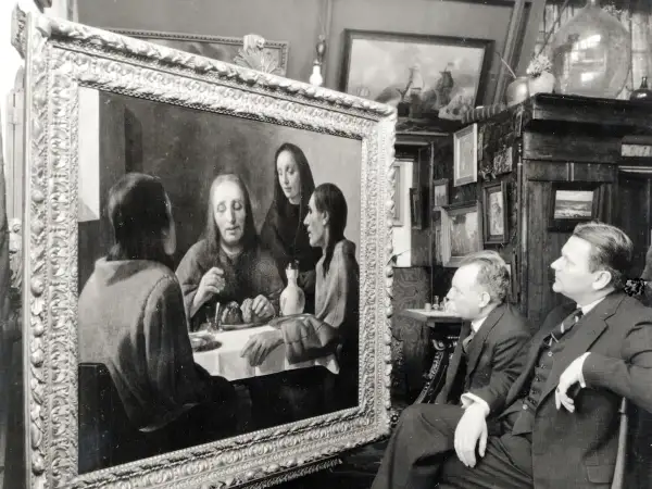 Twee mannen bewonderen een schilderij, mogelijk een van de kunstwerken van Johannes Vermeer, in een kamer vol met andere schilderijen.