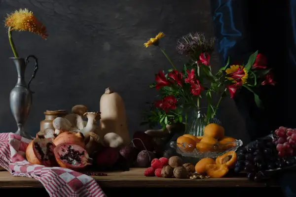 Een rijke **still life** met fruit, groenten, paddenstoelen en bloemen op een houten tafel.